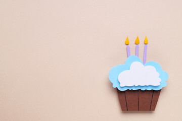 Wall Mural - Birthday party. Paper cupcake with candles on beige background, top view and space for text