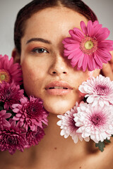 Woman, flowers and studio portrait for beauty, wellness and skincare with spring aesthetic by background. Model, girl and carnation plant with cosmetic health, natural skin glow and symbol for growth