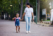 © Nina/peopleimages.com - Walking, park and mother holding hands with girl on journey for back to school, learning and class for first day. Love, black family and mom with child walk to kindergarten for education development