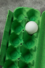 Green Egg Box With One White Egg. Top View.