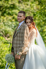 Wall Mural - The bride and groom in a wedding dress in nature.