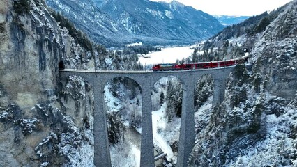 Wall Mural - Aerial view of Train passing through famous mountain in Filisur, Switzerland. Landwasser Viaduct world heritage with train express in Swiss Alps snow winter scenery. 