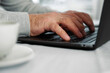 © Marina Demidiuk - Closeup of senior man hands using laptop. Cropped side view of wrinkled caucasian older hands typing keyboard. Old people with technology. Unrecognizable retired male working from home sitting at desk