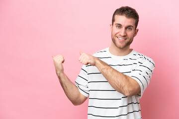 Poster - Young caucasian man isolated on pink background pointing to the side to present a product