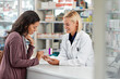 © Reese/peopleimages.com - Happy, customer and pharmacist with healthcare medicine assistance, help and expertise at store counter. Advice and opinion of worker helping girl with medication information at pharmacy.