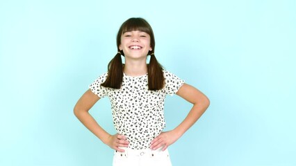 Wall Mural - Little girl  posing with arms at hip and laughing over isolated background