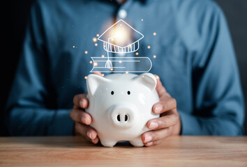Aufkleber - Businessman holding coin into piggy bank with graduation cap and book icons. saving money for future education. Education fees and cost of college graduate. Tuition fees and total cost in education.