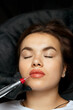Beauty master in gloves applying permanent makeup