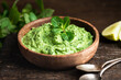 Indian green chutney in a wooden bowl , selective focus