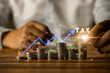 © Viriyastock88 - Concept of tax deduction planning, expenses, accounting, VAT, income tax, foreign tax filing in the country. and property and land taxes. Paying taxes. Hands of businessman and coins on wooden table.