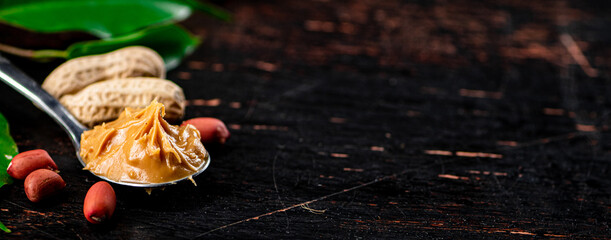 Poster - A spoonful of peanut butter on a table with leaves.