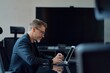 © nyul - Business portrait - Businessman working with laptop computer sitting in meeting room in modern office. Happy middle aged, mid adult, mature age man smiling.