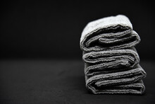 Three Gray Towels On A Black Background. Terry Cloths For Wiping Furniture. Towels On A Black Background.