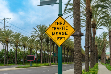 A Thru Traffic Merge Left street sign in Anaheim, California