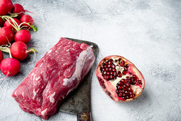 Wall Mural - Fresh Raw Beef steak Mignon, with salt, peppercorns, thyme, garlic Ready to cook, on old butcher cleaver knife, on gray stone background, with copy space for text