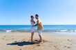 © neirfy - Happy young couple at the sea vacations, man and woman walking at the sea shore, vacations and honeymoon concept