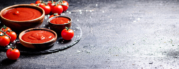 Wall Mural - Tomato sauce in a wooden plate on a stone board with salt. 