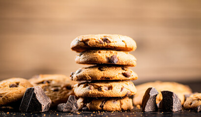 Poster - Pile of homemade cookies with pieces of milk chocolate on the table.