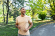© Liubomir - Cheerful and successful hispanic man jogging in the park, man running on a sunny day, smiling and happy having an outdoor activity.