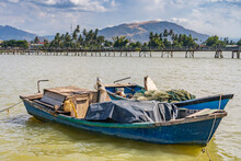A  Rustic Fishing Boat At Anchor On A Wide River With Distant Mountains At Nah Trang In Vietnam