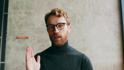 A young red-haired guy, in a stylish cafe. Vlog recording, online video conference, video call, online learning, lessons, lecture. Interview, online training. View from the webcam.