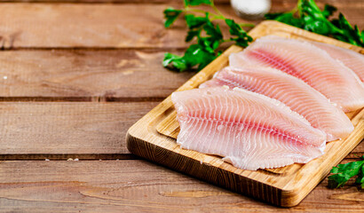 Wall Mural - Raw fish fillet with parsley on a cutting board. 