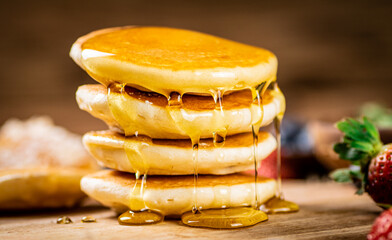 Wall Mural - Homemade pancakes with honey on the table. 