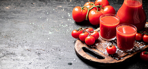 Poster - Glasses of tomato juice on a cutting board. 