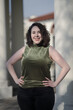 © Levi Meir Clancy - A woman with pale skin and black, wavy hair poses confidently outdoors.