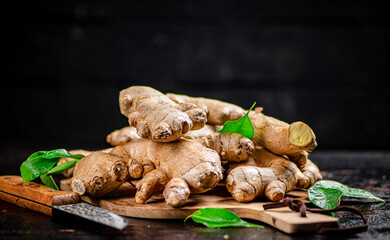 Ginger on a cutting board with a knife. 