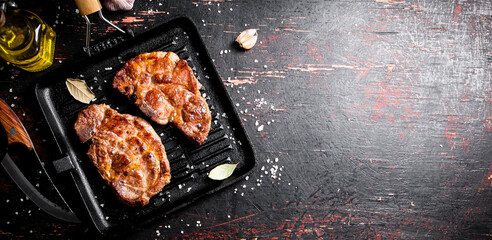 Wall Mural - Grilled pork steak in a frying pan. 