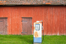 Old Rusty Petrol Pump By A Red Barn In The Countryside