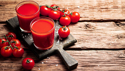 Poster - Glasses with tomato juice on a wooden cutting board. 