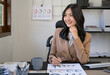 © Fahng - Joyful woman smiling while working. Positive happy female employee resting at workplace, looking away from computer screen. Relaxed woman office worker taking break to refresh mind  during workday.