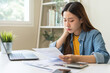 © KMPZZZ - Financial owe, hand of asian woman sitting, holding credit card, stressed  by calculate expense from invoice or bill, no money to pay, mortgage or loan. Debt, bankruptcy or bankrupt.