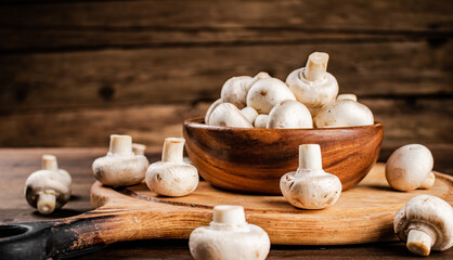 Canvas Print - Mushrooms in a bowl on a cutting board. 