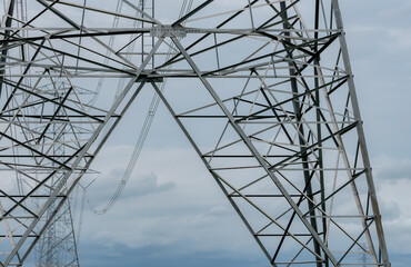 Wall Mural - High voltage electric transmission tower. High voltage power lines against blue sky. Electricity pylon and electric power transmission lines. High Voltage tower provide power supply. Power and energy.