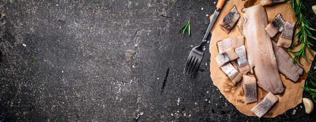 Poster - Pieces of salted herring on paper with rosemary and garlic. 