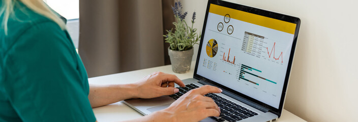 businesswoman analyzing statistics on laptop screen, working with financial graphs charts online, using business software for data analysis and project management concept, rear close up view