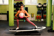 © djile - Young woman exercise with a ball on a surfboard in the gym