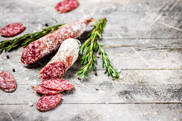 Poster - Pieces of salami sausage with sprigs of rosemary. 