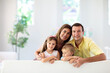 © famveldman - Happy family at home. Parents and kids on couch.