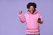 © insta_photos - Excited happy African teen guy winner holding cell phone winning game online on cellphone, using mobile apps technology celebrating victory receiving message isolated on light purple background.