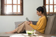 © wichayada - People relax at home and wellness lifestyle. Young adult asian woman eating salad and using laptop computer for watching online movie on internet.