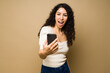 © AntonioDiaz - Excited woman texting and looking surprised