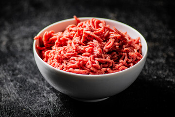 Bowl on the table with fresh minced meat. 