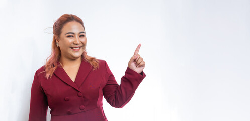 Pointing upper and side hand with finger. Plus size asian business woman show product on hand standing on white background. Looking at camera. Isolated on white.