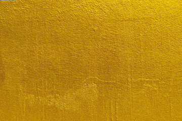 Wall Mural - Gold wall texture background. Yellow shiny gold foil paint on wall sheet with gloss light reflection, vibrant golden luxury wallpaper