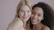 © supamotion - Candid portrait of two beautiful 20s females, African-American Black and Caucasian, posing against solid background, no make-up, studio shot, soft lighting