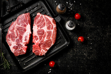 Poster - Raw steak pork on a grilled pan with cherry tomatoes and rosemary. 